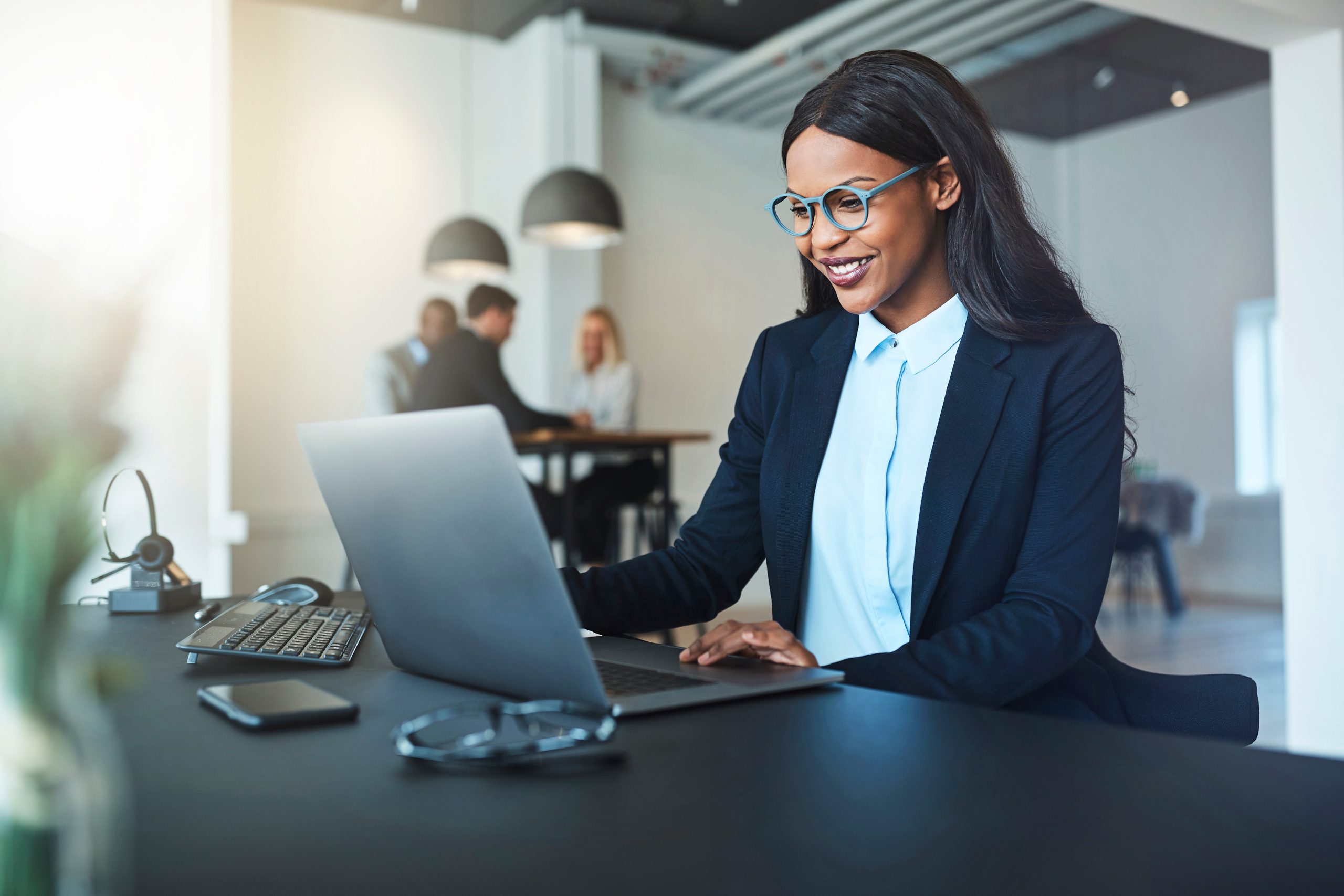 Smiling young African American businesswoman working on a laptop.