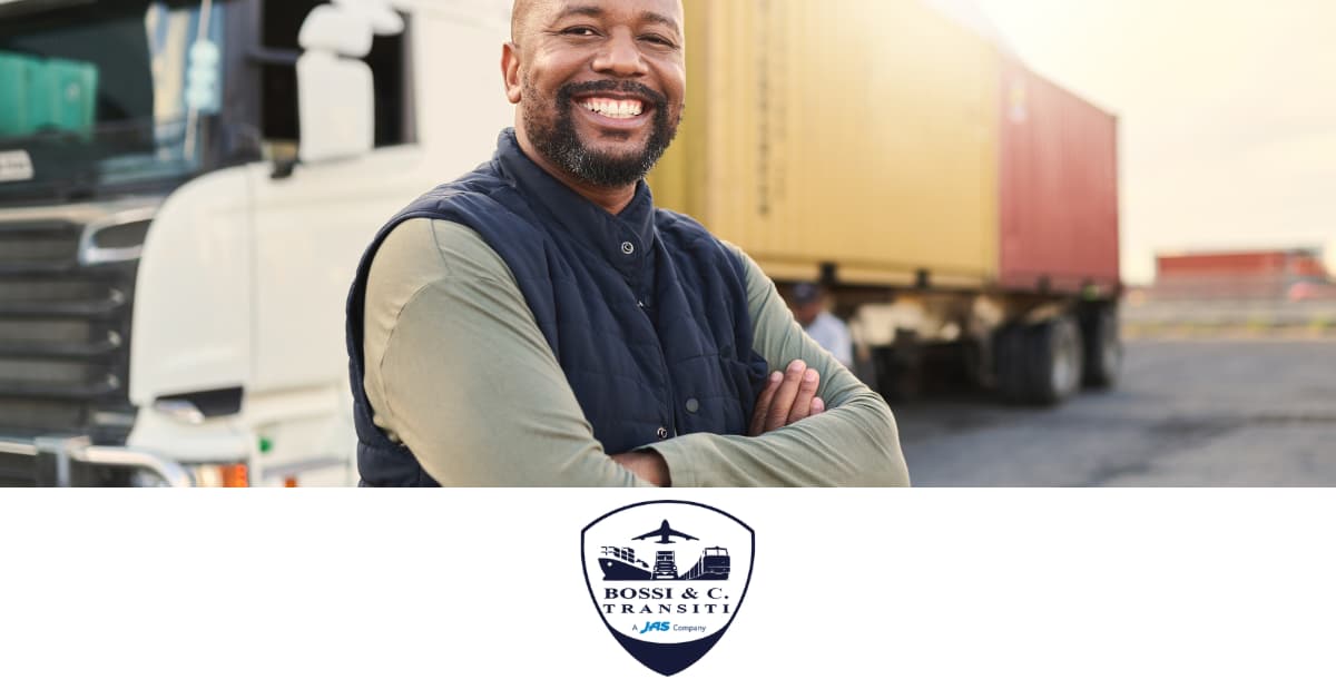 Smiling man in front of a parked truck with a yellow cargo container.